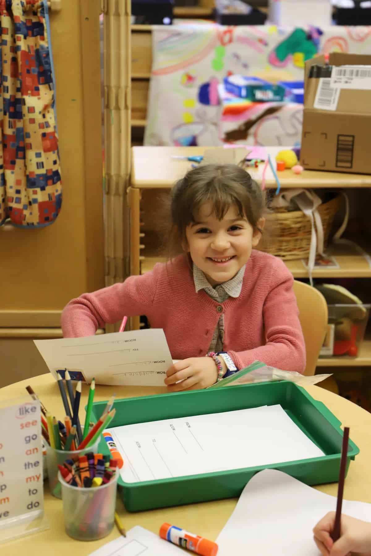 Student smiles at camera while working on post office project